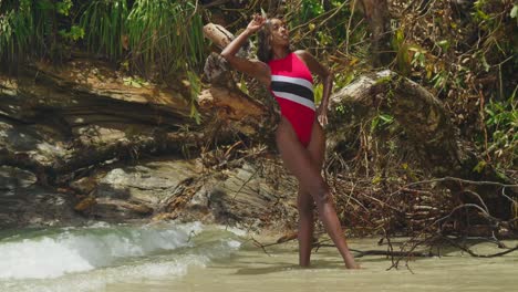 On-a-north-coast-beach-in-Trinidad,-a-young-girl-is-seen-in-a-Trinidad-flag-bikini-in-the-Caribbean