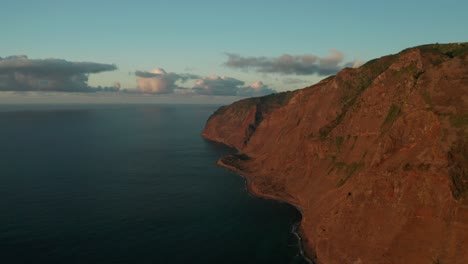 Antenne-An-Der-Ruhigen-Küste-Von-Madeira,-Die-Vom-Schein-Des-Sonnenuntergangs-Beleuchtet-Wird