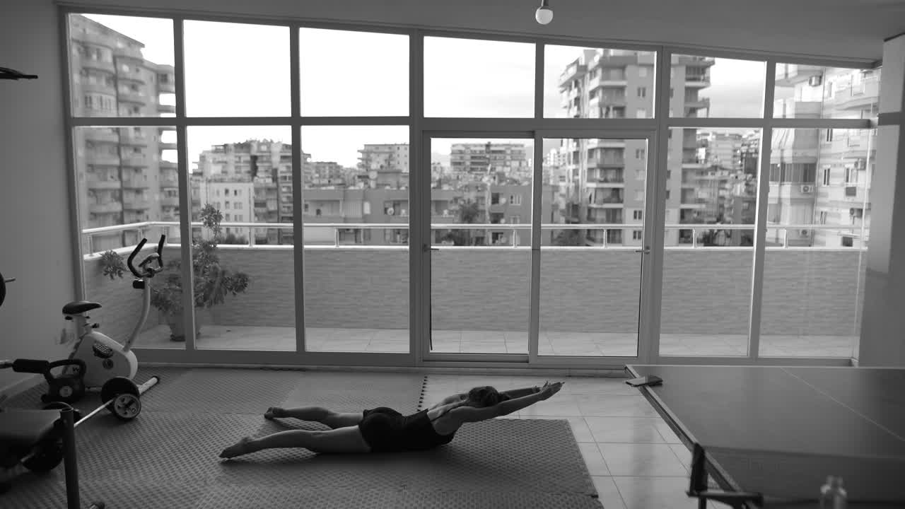mujer practicando yoga o estirándose en un gimnasio en casa