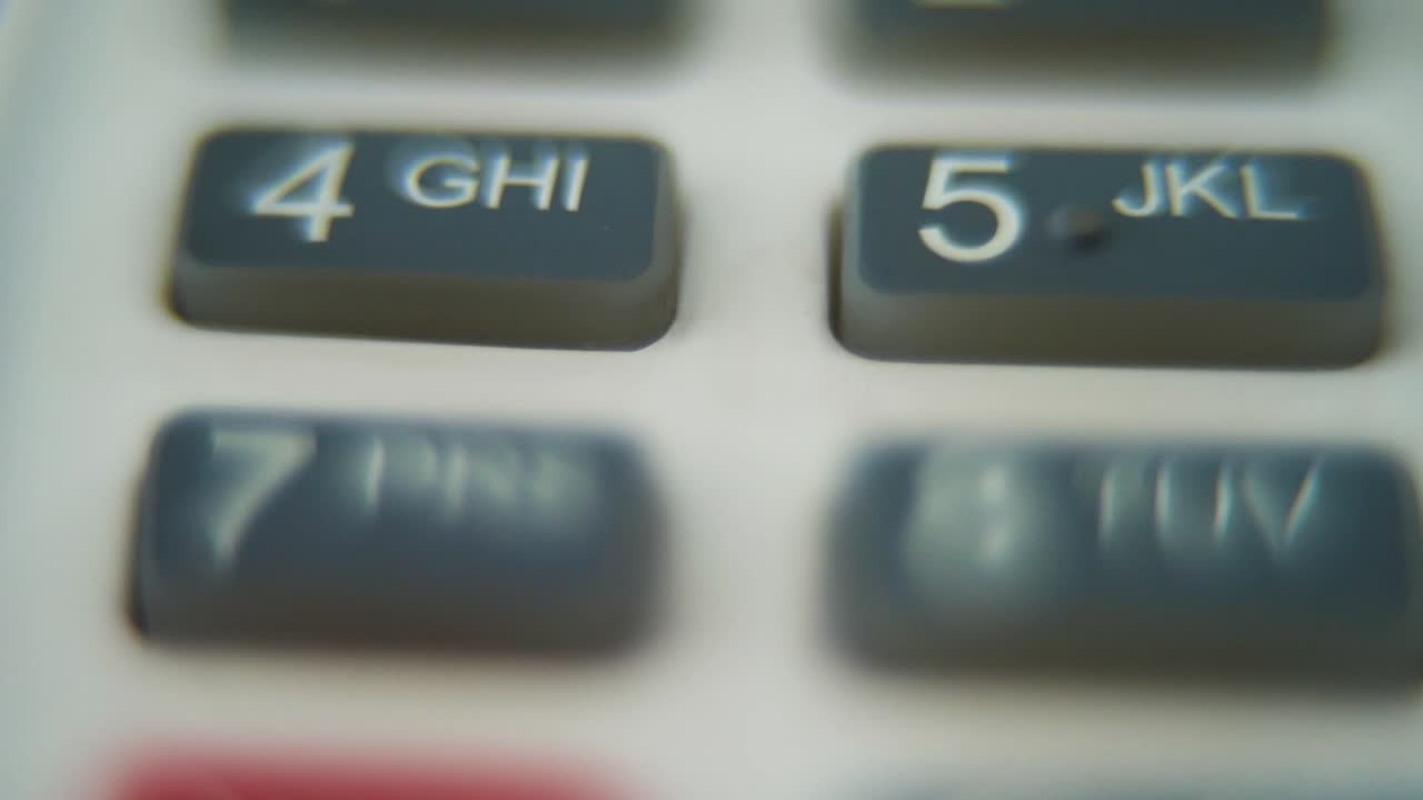 A macro close up shot of a pin pad numbers and letters on colorful buttons, smooth zoom in movement, Full HD video, super slow motion, blurry depth of field