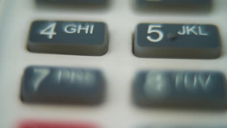 a macro close up shot of a pin pad numbers and letters on colorful buttons, smooth zoom in movement, full hd video, super slow motion, blurry depth of field