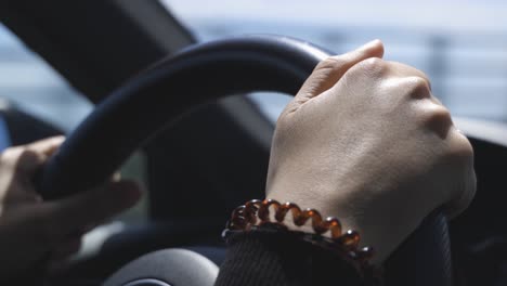 Woman-driving-a-car,-closeup-of-her-Hands-and-the-steering-Wheel