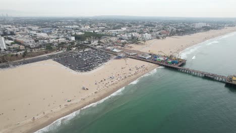 Aerial-view-across-Santa-Monica-pier-and-sandy-golden-beach-holiday-hotels-skyline