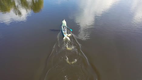 aerial view of person kayaking/paddleboarding on a river