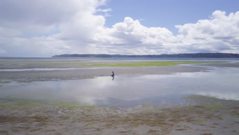 Große-Luftaufnahme-Eines-Jungen,-Der-Bei-Ebbe-Im-Sand-Am-Strand-Spielt