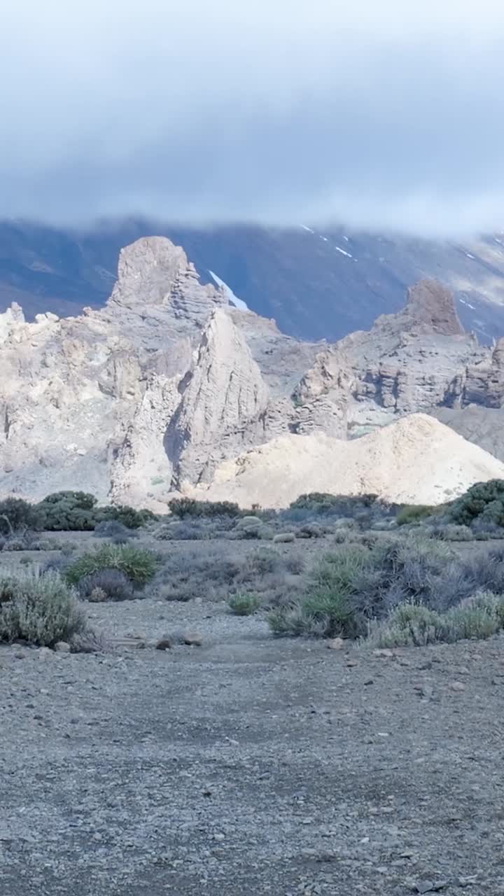 Paesaggio vulcanico aspro con imponenti formazioni rocciose e nuvole distanti