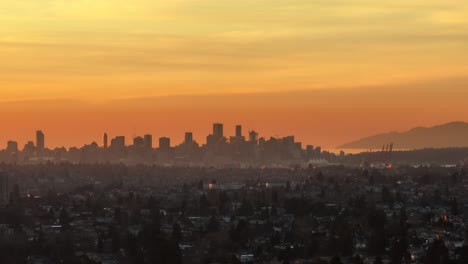 Aerial-trucking-of-touristic-Vancouver-city-skyline-at-sunset-with-colorful-orange-sky,-British-Columbia,-Canada