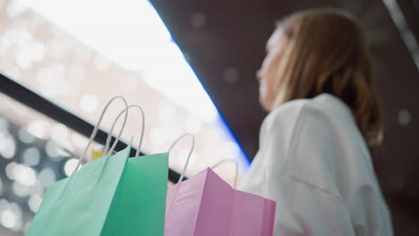 colorful shopping bags with blurred woman in background and bright glass reflections, captures urban shopping lifestyle and modern aesthetic