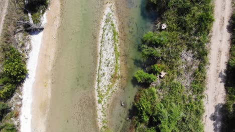 Top-down-view-of-river-with-road-that-parallels-it-on-the-right