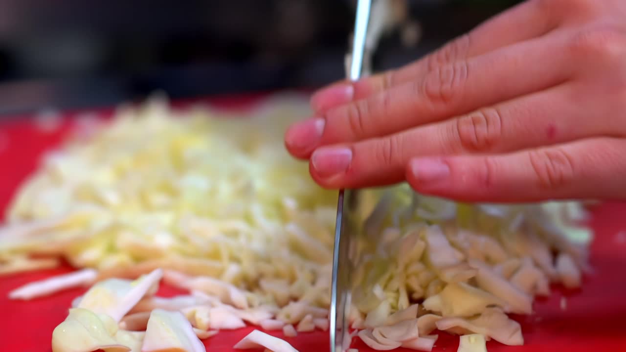 Hands mince cabbage in slow motion, showing detail and texture of food preparation
