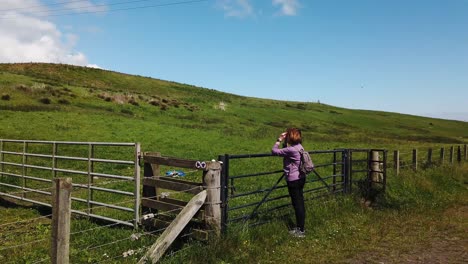 woman rambler takes a break and takes in the countryside views on the scotland fife coastal path