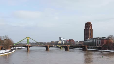 Lindner-Hotel-And-Residence-Main-Plaza,-Ignatz-Bubis-And-Raftsman-Bridge-Over-Main-River-In-Winter-At-Frankfurt-am-Main,-Germany