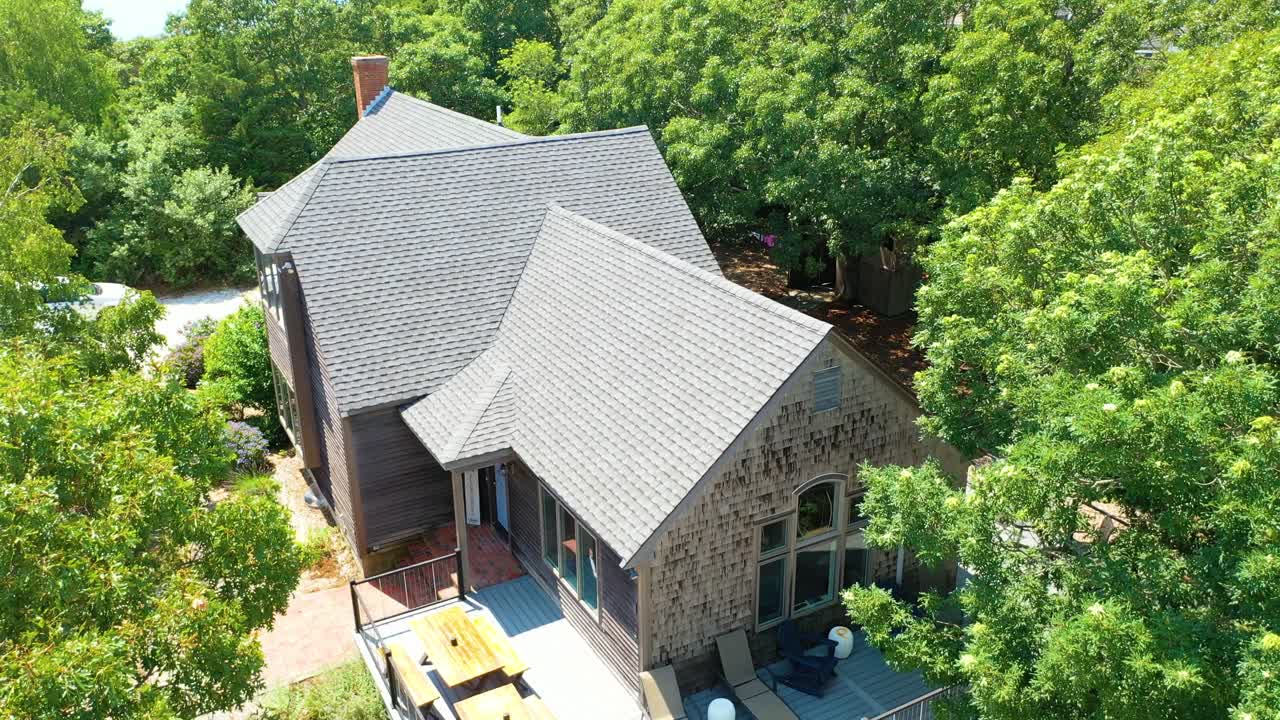 The rustic-inspired residence with sharp rooflines and a stone chimney is highlighted in a steady gimbal glide, showing both architectural details and natural surroundings
