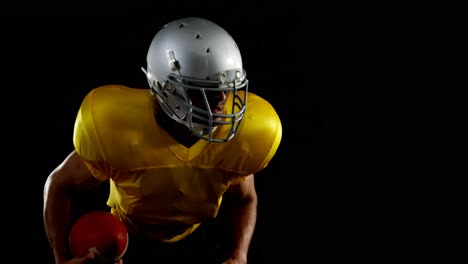 American-Football-Spieler-Lehnt-Sich-Nach-Vorne-Und-Hält-Einen-Ball-4k