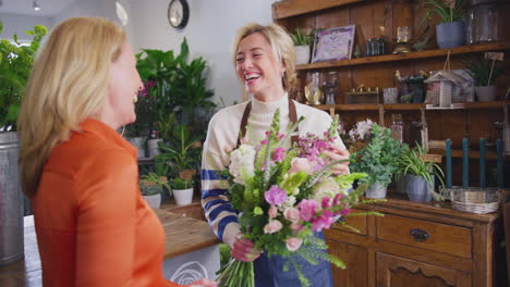 female customer in florists shop buying bouquet of flowers