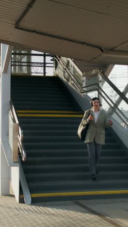 businesswoman walking upstairs at train station