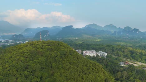 Wide drone shot of Kelantan’s limestone hills draped in lush rainforest, showcasing Malaysia’s natural beauty, misty horizons, and untouched tropical wilderness