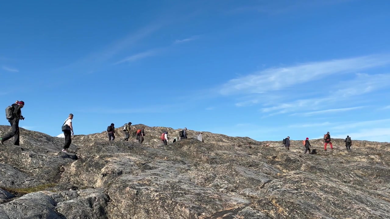 Un gruppo di turisti cammina sulle scogliere dell'isola di Danimarca, Scoresbysund, Groenlandia.