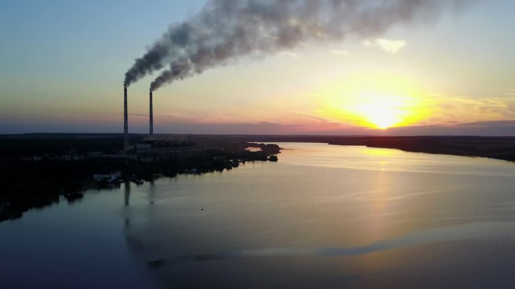 Landscape of an industrial estate with pipe factory smoke near river