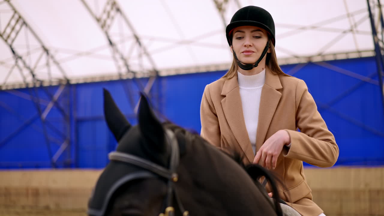 Woman Riding a Horse in an Indoor Arena