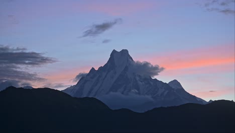 sunset mountain top and dramatic sky in nepal, beautiful sunset over mountains summit in blue hour at poon hill viewpoint while hiking and trekking in nepal, big snowcapped mountain peak