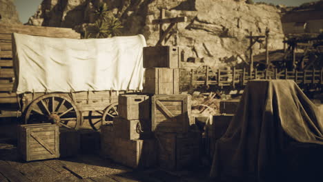 historic wooden crates and wagon in a desert landscape during sunlight hours