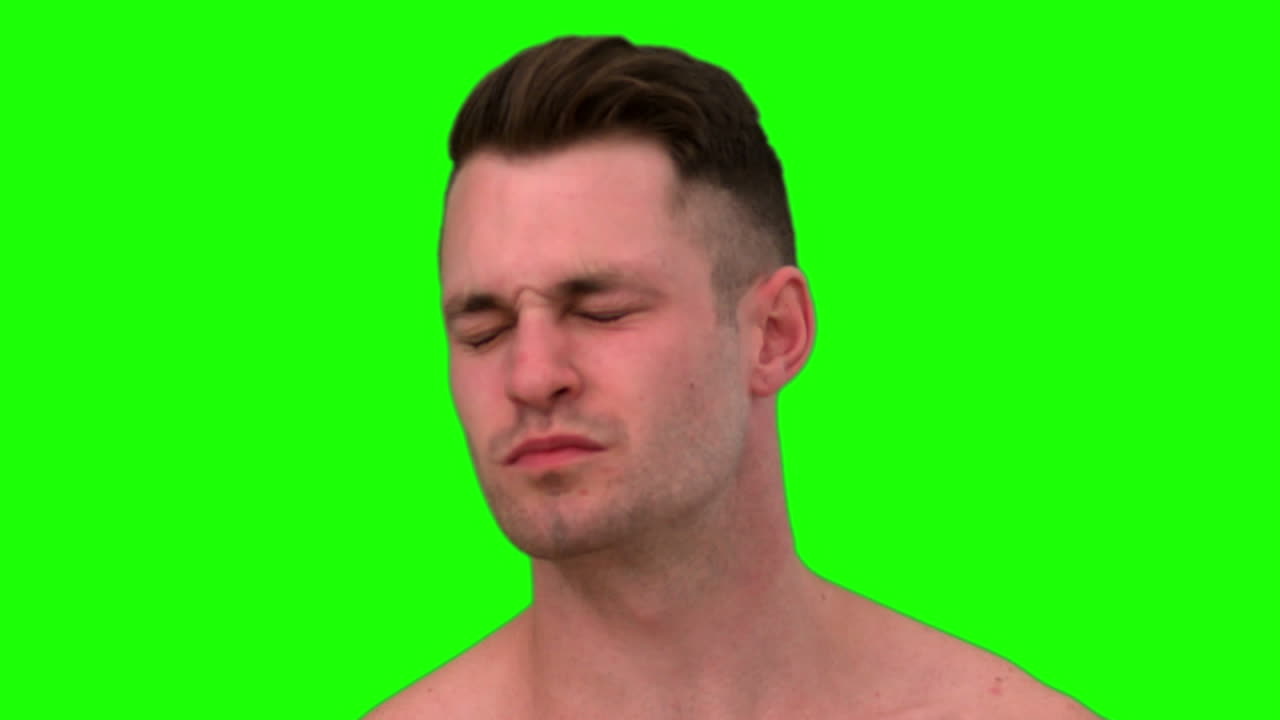 hombre serio tomando una bofetada en el fondo verde