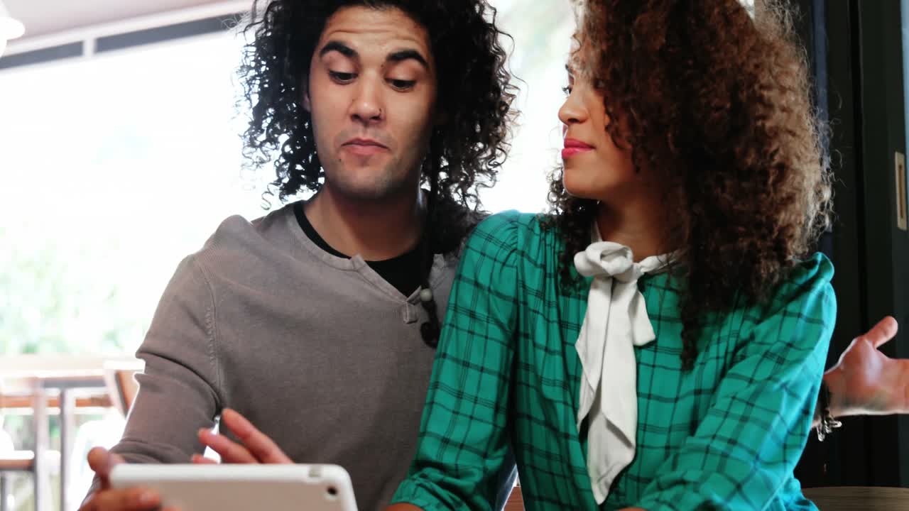 Couple using digital tablet and interacting with each other