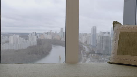 child with teddy bear at window