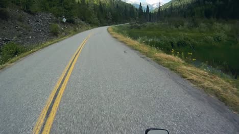 Clip-Pov-De-Un-Motociclista-En-Un-Sinuoso-Camino-Forestal-De-Montaña-En-El-Verano