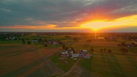 Vista-Aérea-De-La-Puesta-De-Sol-Sobre-Las-Tierras-De-Cultivo-Amish-En-Pennsylvania-En-Junio