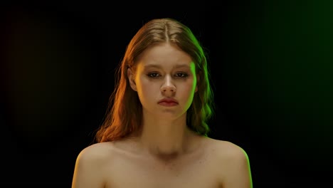 portrait of a young woman bathed in colorful studio light