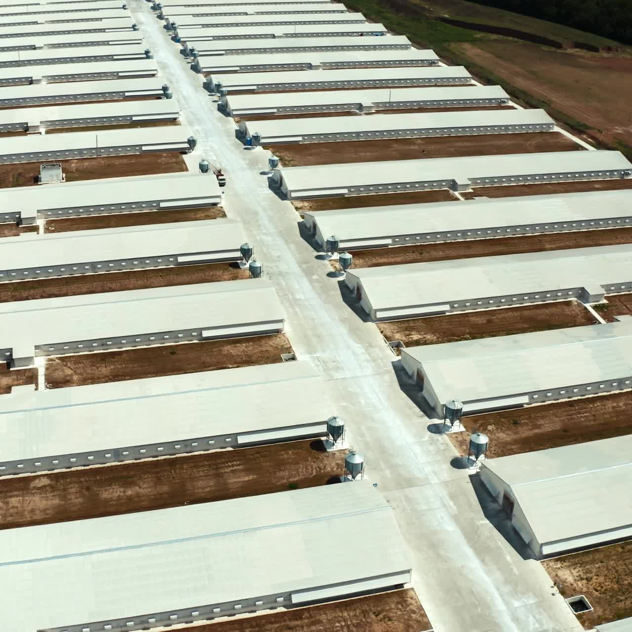 White buildings of manufacturing on the field. View from above on a new industrial complex. Flight over warehouses. Aerial view.