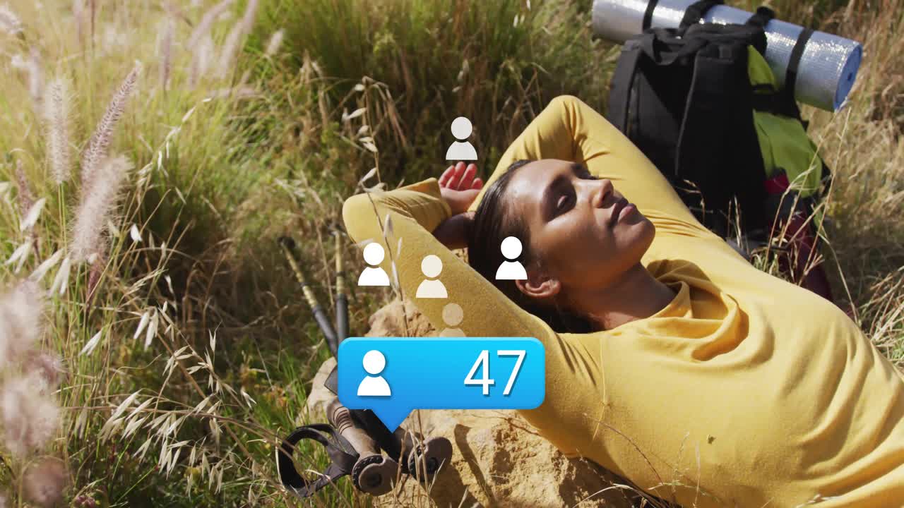 Social media user reclining in meadow seeing follower overlay appearing at torso and rising to 95