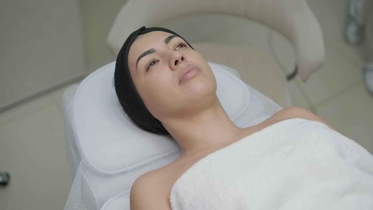 현대 화장품 클리닉에서 보리넘 치료를하는 여성 전문 화장품 전문가는 얼굴 피부를 재생시키기 위해 보리 독소를 주사합니다. 매력적인 여성 환자 주름을 부드럽게합니다.