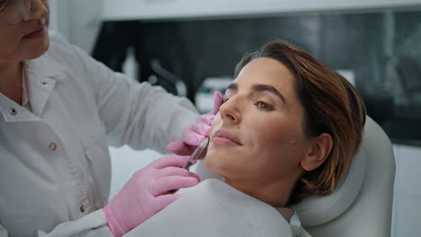 mujer haciendo inyección de belleza en la clínica de cosmetología de cerca. rejuvenecimiento de la piel.