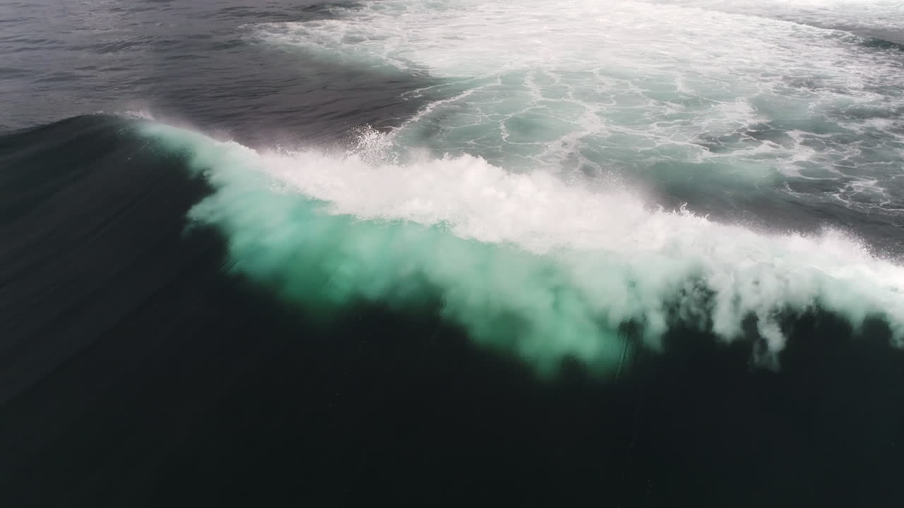 Misty spray lifts off curling wave as whitewater crashes down in slow motion