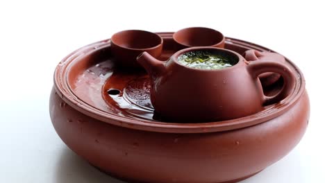 close up red brown clay fired teapot and teacups on white background.