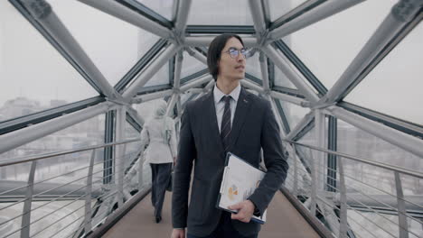 businessman walking on a modern city bridge