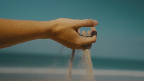 Hand-Mit-Sand-Am-Tropischen-Strand.-Nahaufnahme