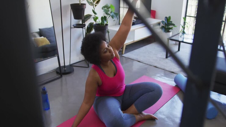 African american female plus size sitting on exercise mat working out