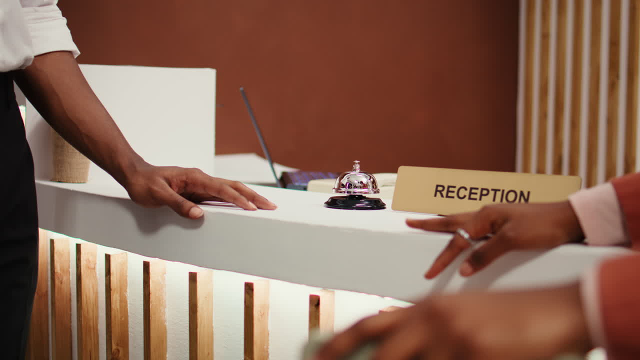 Tourists ringing concierge bell close up