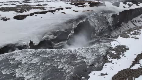 the breathtaking dettifoss waterfall in iceland is captured in a beautiful shot, showcasing a black mountain adorned with a layer of dazzling white ice