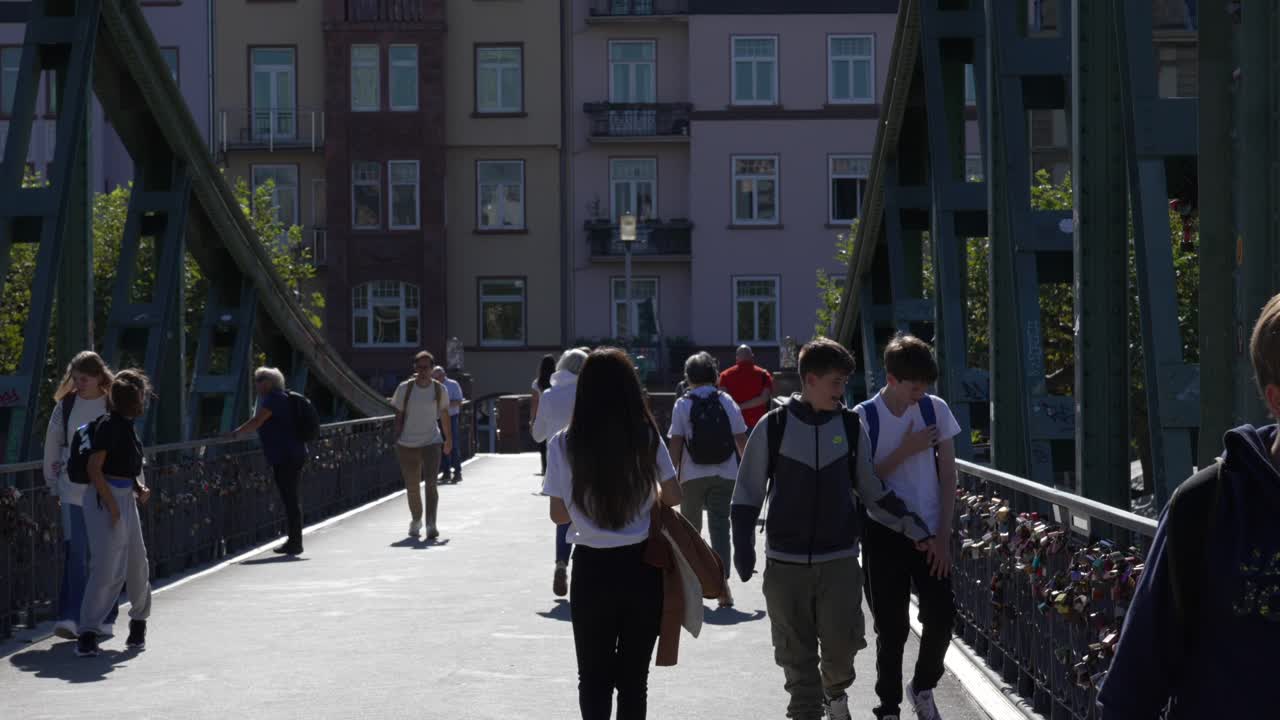 People walking on a pedestrian bridge in a city