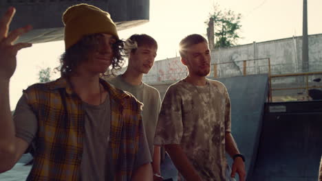 calm hipsters walking together in skatepark. boys enjoying time at fresh air