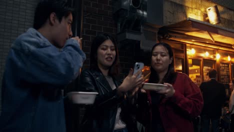 friends enjoying street food at night in japan