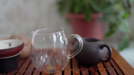 ceremonia del té en una mesa portátil. agua caliente se vierte en una pequeña tetera con hojas de té
