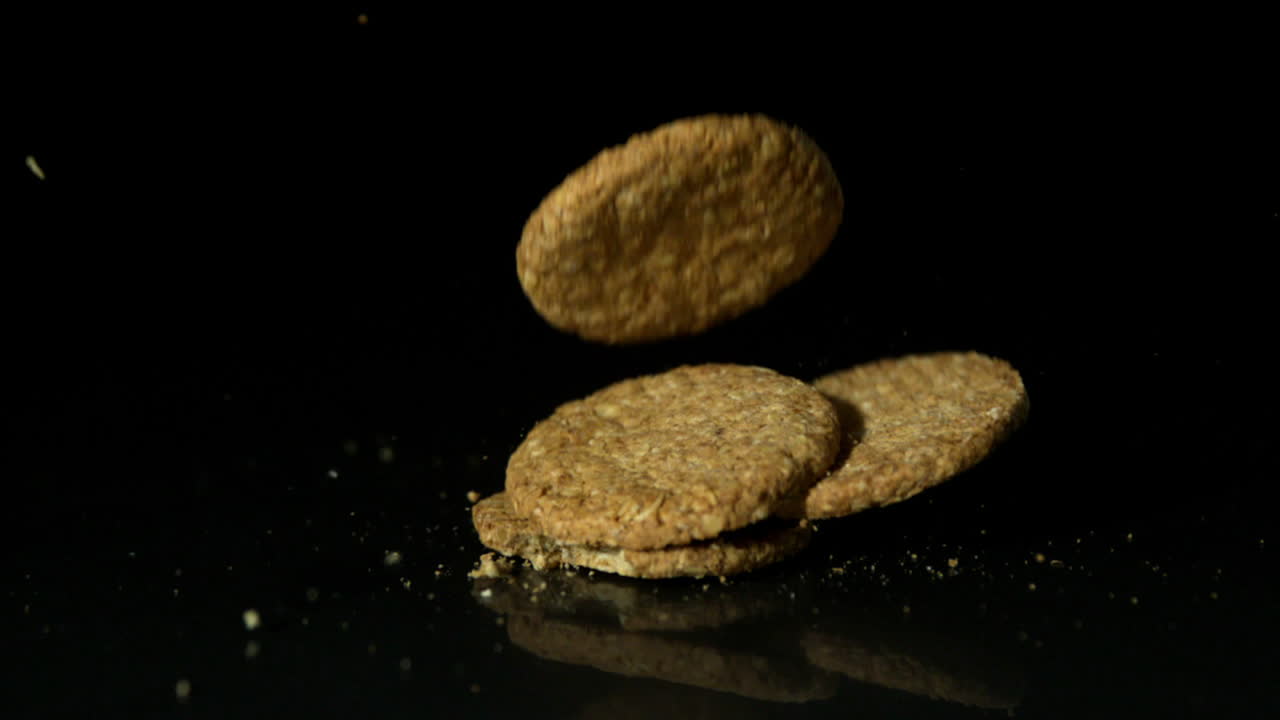 Biscuits falling on black surface