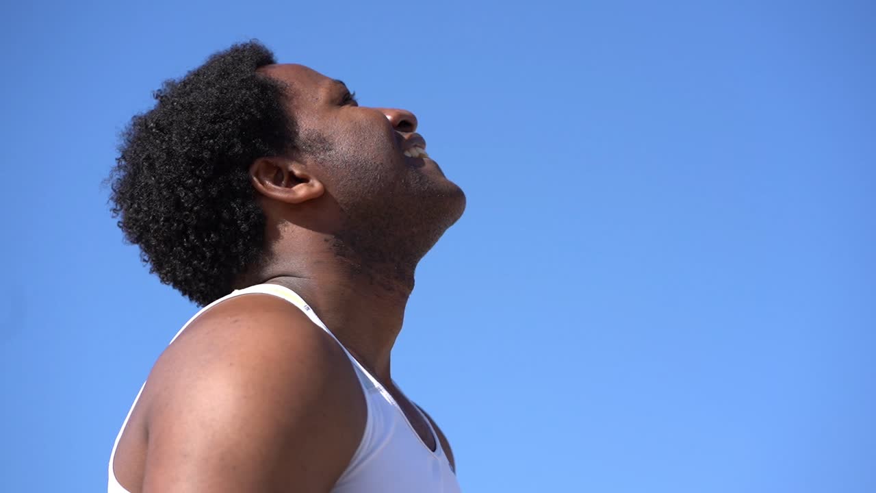 vista lateral de un deportista agotado limpiando el sudor después del entrenamiento al aire libre