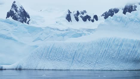 big blue antarctica iceberg ice formation, antarctica ice floating in ocean close up, antarctic peninsula icy cold winter scenery with amazing patterns, iceberg detail in icy scenery scene